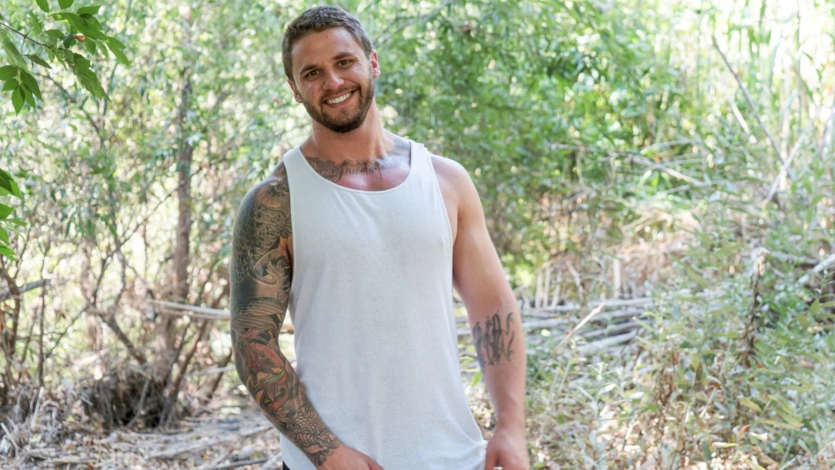 Adult model wearing a white tank top outdoors