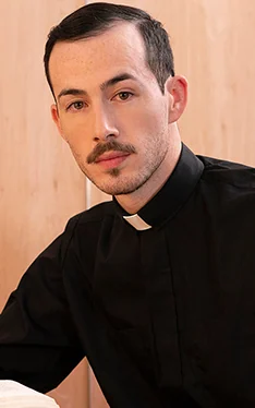 Adult model Father Fiore in a black shirt with a clerical collar